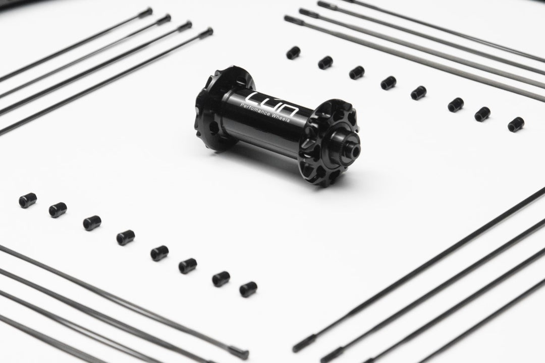 Black bicycle hub with spokes and nipples for repair or customization.