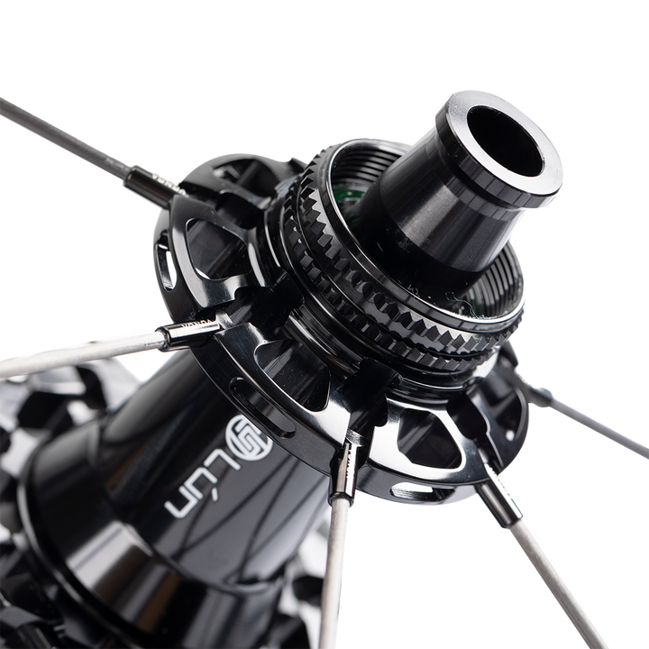 Close-up of HYPER 3 D33 rear disc brake wheelset hub: black titanium ratchet, carbon spokes, T-LOCK nipples, and LUN logo.