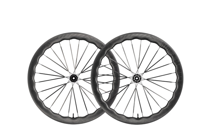 Two UNAAS Pro2 carbon fiber bicycle wheels with distinctive wave rims and black hubs.