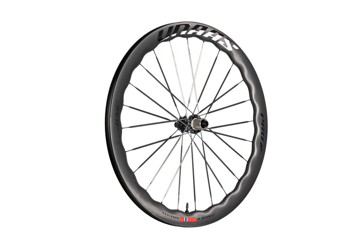 UNAAS Pro2 carbon bicycle wheel with wave rim, white UNAAS branding, black hub, and Norwegian flag detail.