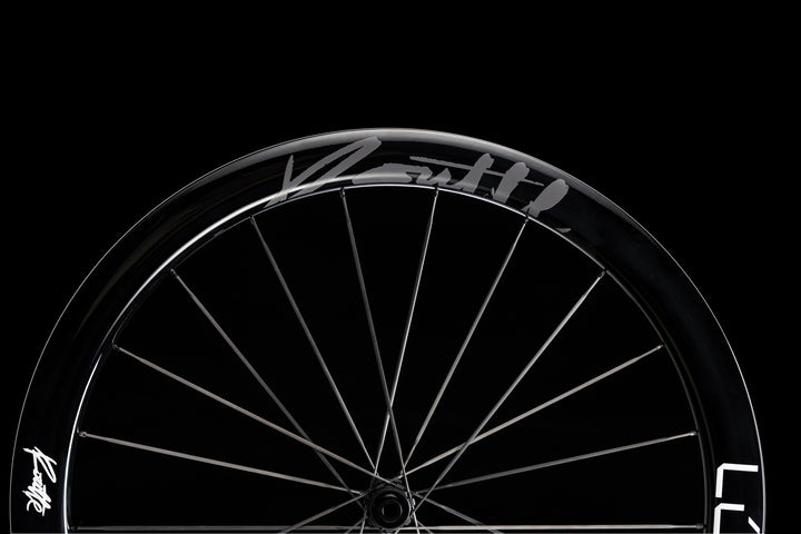 Lún Routte 3 glossy black carbon fiber bicycle wheel with silver spokes and branding.