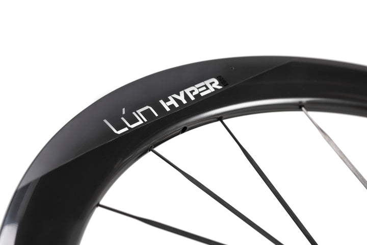 Matte black LUN HYPER 5 carbon fiber bicycle wheel with thin dark spokes and white LUN HYPER logo on rim.