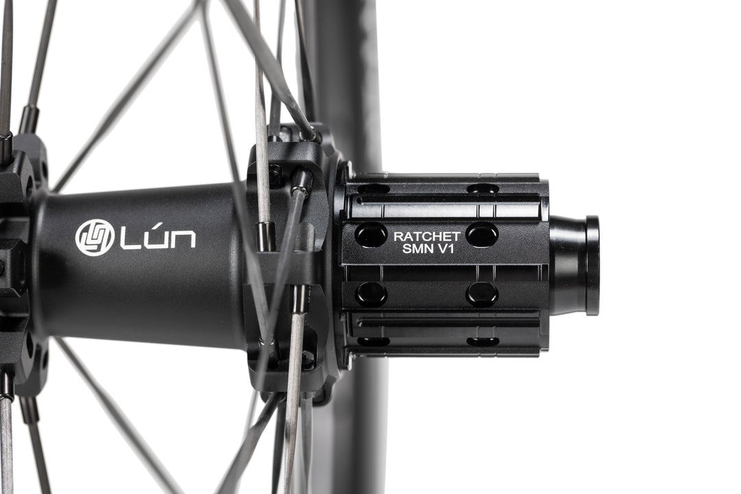 Close-up of matte black LUN HYPER 5 bicycle hub with RATCHET SMN V1 freehub body and thin spokes.