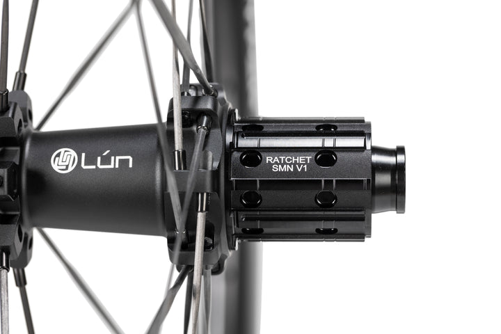 Close-up of matte black LUN HYPER 5 bicycle hub with RATCHET SMN V1 freehub body and thin spokes.