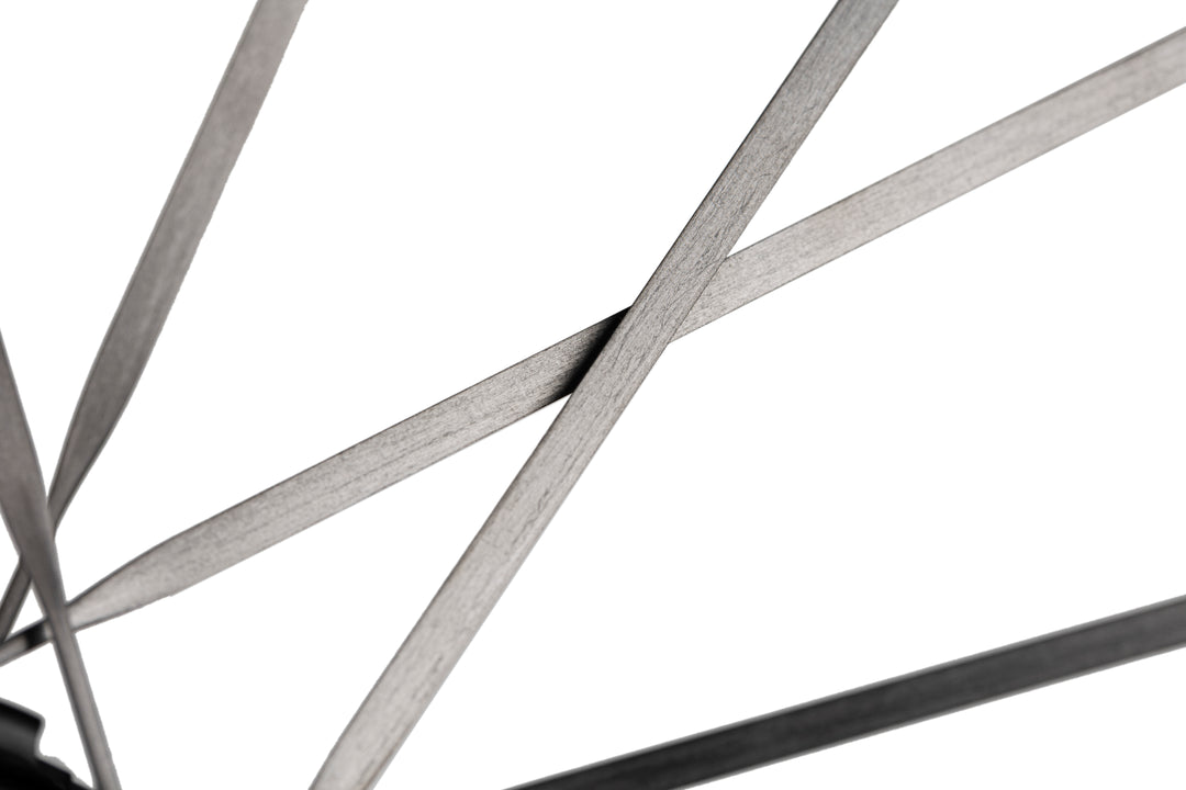 Close-up of HYPER 5 bicycle wheel with thin, flat, dark grey spokes against a white background.