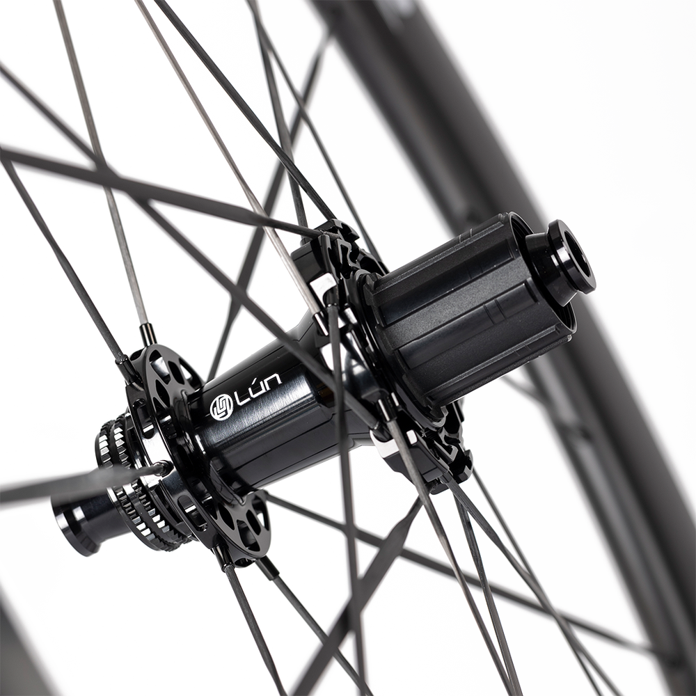 HYPER 3 D45 carbon wheel hub detail: matte UD, black freehub, carbon spokes, Lún branding. Shows hub/spoke details.