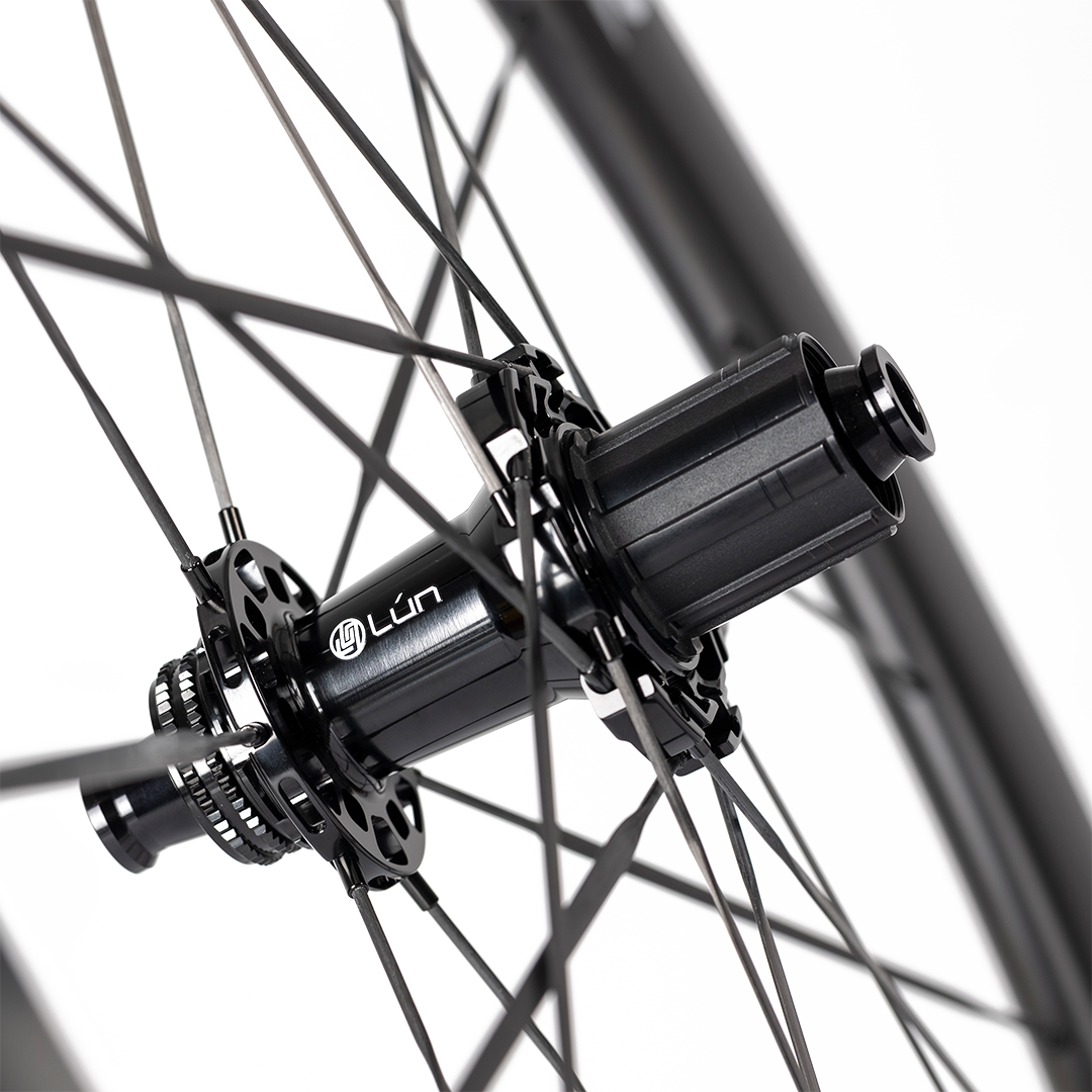 HYPER 3 D67 disc brake wheelset rear hub with wide carbon spokes, titanium ratchet, and "Lún" branding.