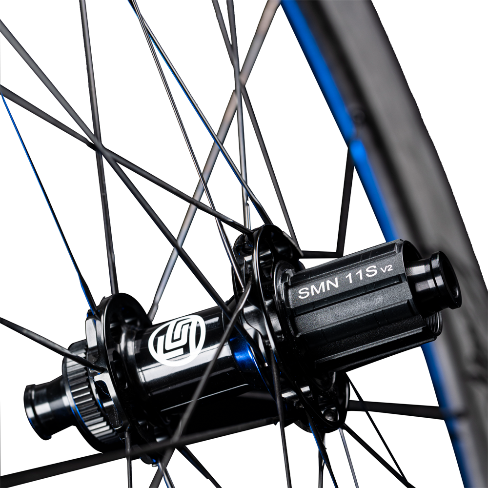 Lún Routte carbon wheelset hub detail: black, white Lún logo, SMN 11S v2, blue accents. Product page detail.