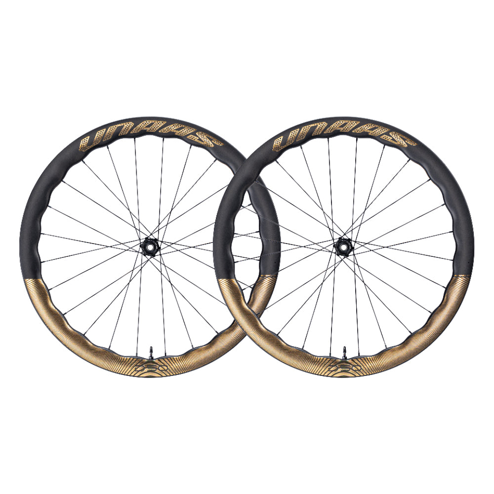 Unagi carbon fiber bicycle wheelsets, dark gray rims with gold accent bands and lettering.